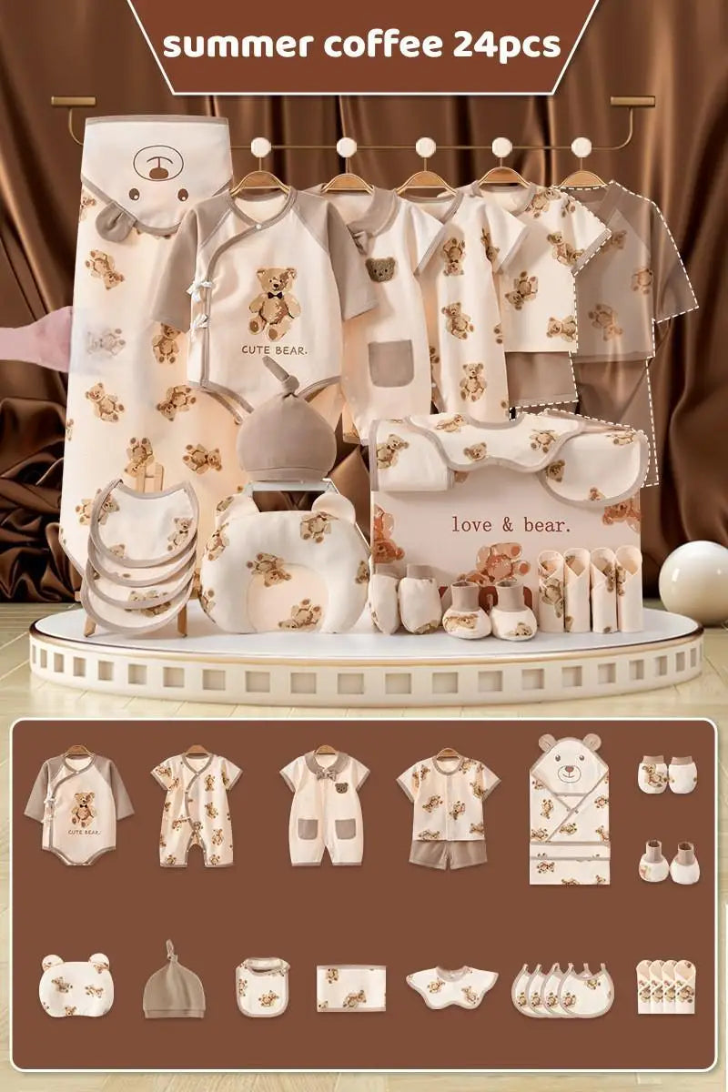 Set of 24 beige baby clothes and accessories featuring bear designs, including rompers, bibs, a hat, burp cloth, mittens, and a hooded towel, displayed on a circular stand.