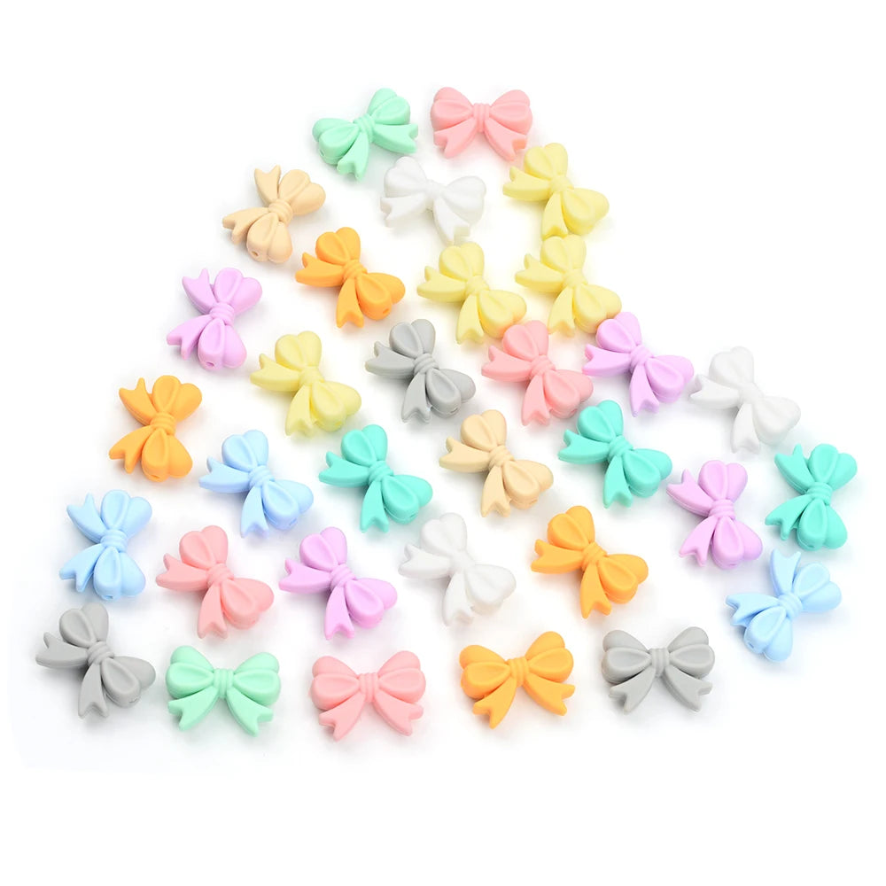 Assorted pastel-colored decorative bows arranged in a triangular pattern on a white background. The bows come in pink, yellow, orange, green, blue, purple, gray, and beige.