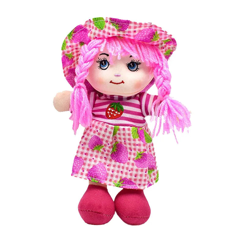 Cute doll with pink braided hair, wearing a matching strawberry-patterned dress and hat on a checkered background. The doll has a sweet smile and bright pink shoes.