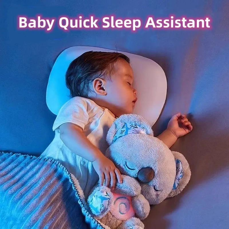 A baby sleeps peacefully on a pillow, hugging a soft koala plush toy under a blue blanket. Above, the text reads "Baby Quick Sleep Assistant" in pink letters.