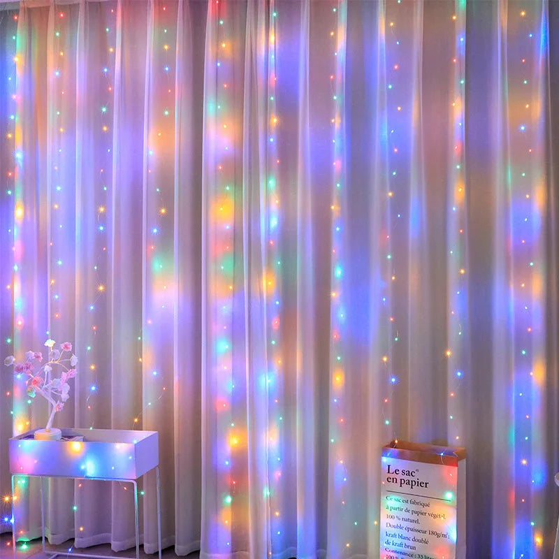 Colorful fairy lights drape over sheer curtains, casting a rainbow glow. A white side table with a small plant and a paper bag labeled "Le sac en papier" sit below the lights.