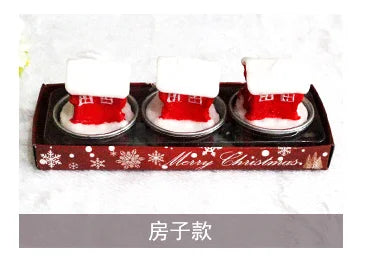 Three red and white Christmas house candles in a festive tray with "Merry Christmas" written on it, alongside snowflake designs. Chinese text appears below the candles.