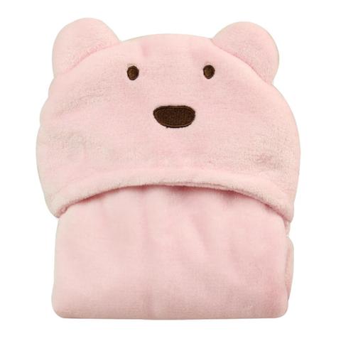 Soft pink baby blanket with a cute bear face, featuring embroidered eyes and nose. The blanket is folded neatly, showcasing its plush texture and adorable design.