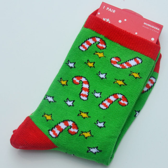 Green socks with red toes and cuffs featuring white and red candy canes, and yellow and white stars. The packaging is partially visible at the top.
