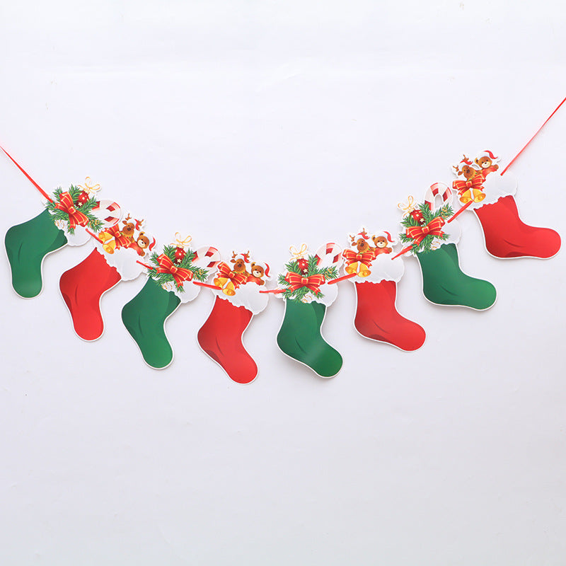 A festive garland features alternating red and green paper stockings adorned with playful reindeer graphics and Christmas decorations, hung on a red string against a white background.