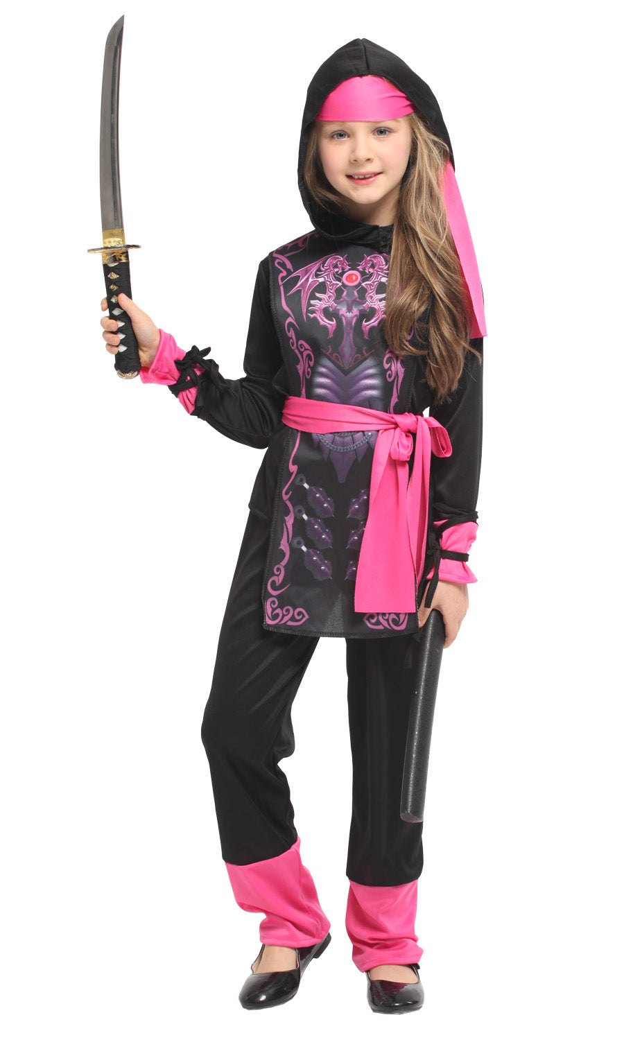 Young girl dressed as a ninja in a black and pink costume, holding a sword. Her outfit features pink accents and decorative patterns, with a headband and belt matching the theme.