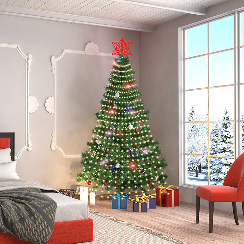 A decorated Christmas tree with colorful lights and a red star topper stands beside a window with a snowy view. Presents are arranged underneath in a cozy, modern bedroom.