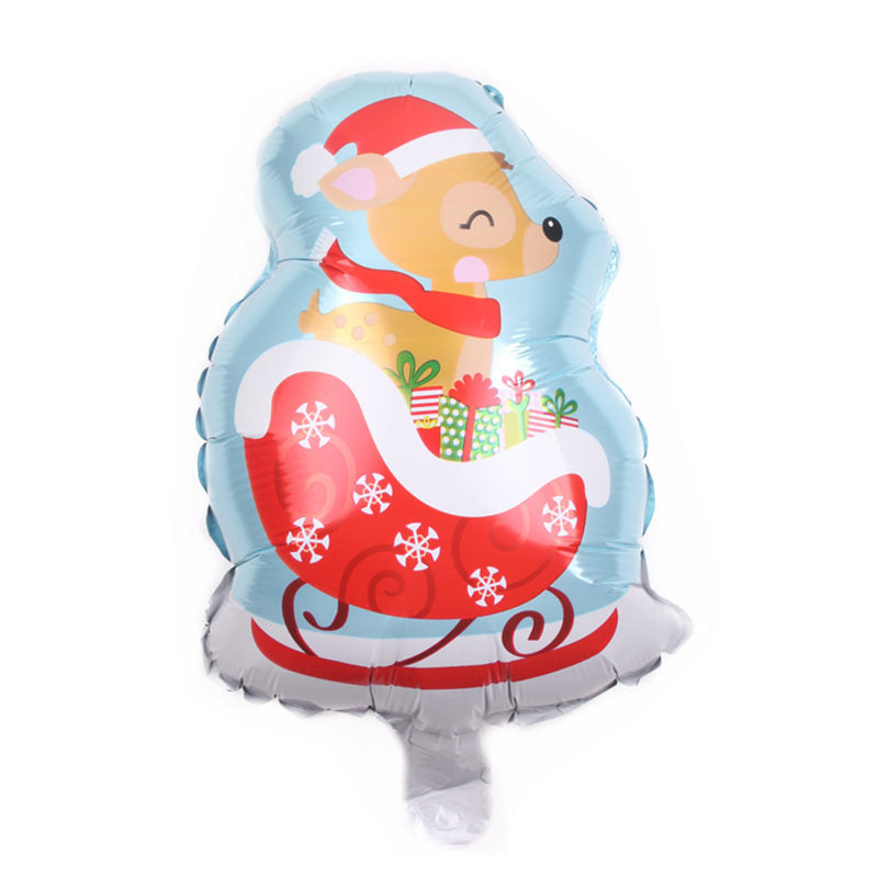 A festive balloon featuring a cartoon reindeer wearing a Santa hat and scarf, sitting in a red sleigh adorned with snowflakes and filled with colorful wrapped gifts.