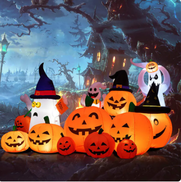Inflatable Halloween decorations featuring jack-o'-lanterns and ghosts with witch hats. A spooky haunted house and leafless trees form the eerie background under a twilight sky.