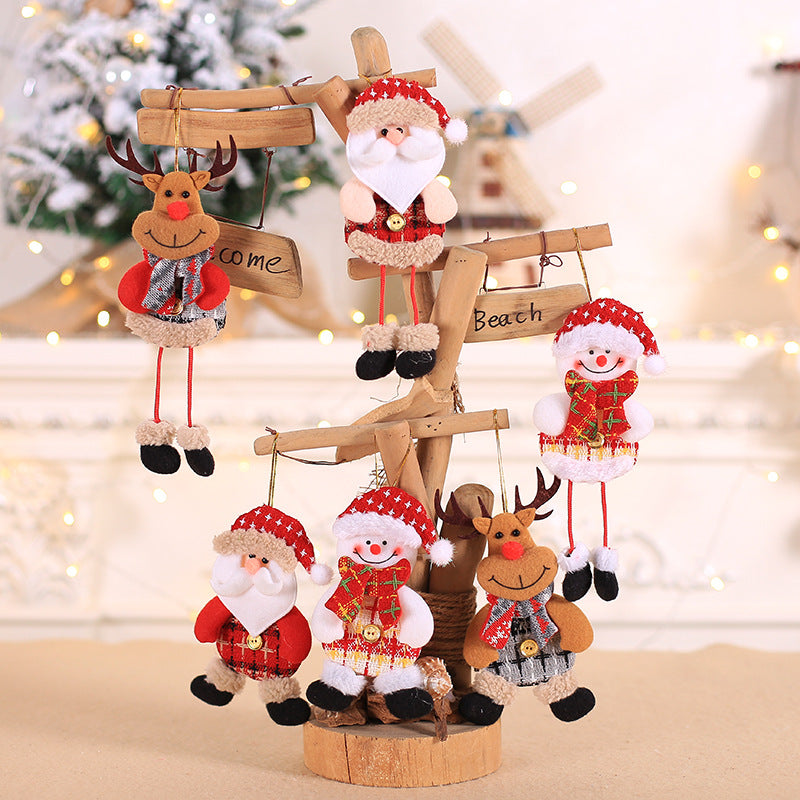 Festive Christmas decorations on a wooden stand, featuring Santa, snowman, and reindeer plush figures wearing red and white outfits, set against a softly lit background.