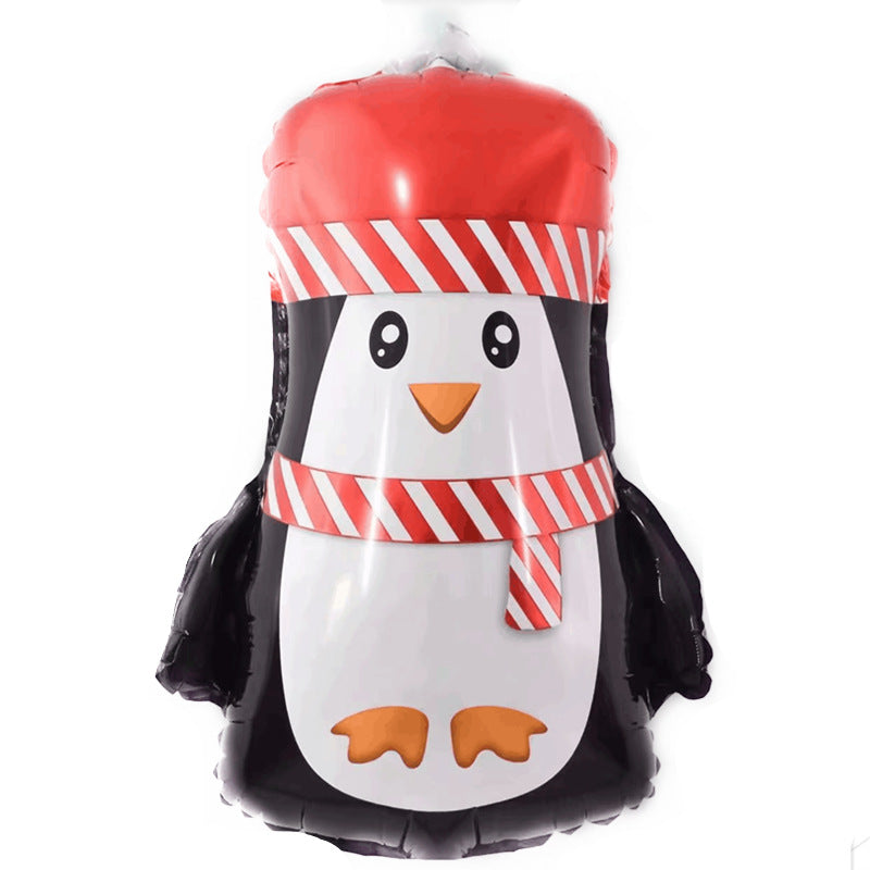 A penguin-shaped foil balloon wearing a red and white striped hat and matching scarf, with large cartoon eyes and orange beak, set against a plain white background.