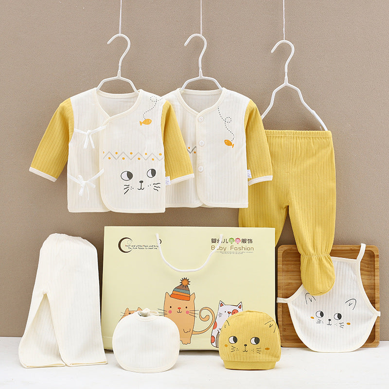 Baby clothing set with cat designs, featuring two cream and yellow tops, yellow pants, a bib, a hat, and a towel, displayed with a cat-themed gift bag.