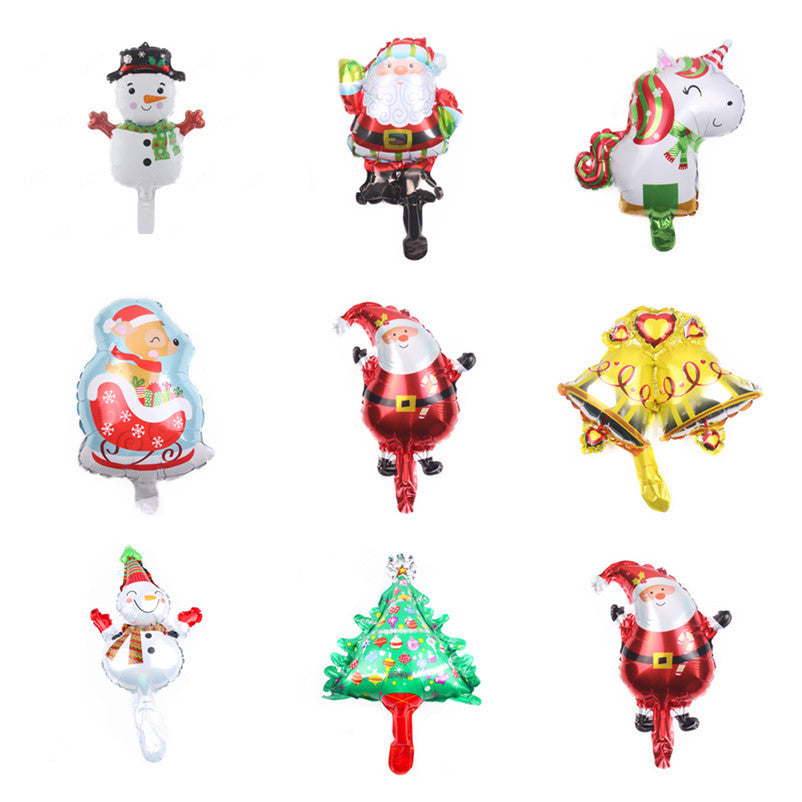 A grid of nine festive foil balloons: snowmen, Santas, a unicorn, a reindeer, golden bells, and a Christmas tree, each with vibrant colors and cheerful designs.