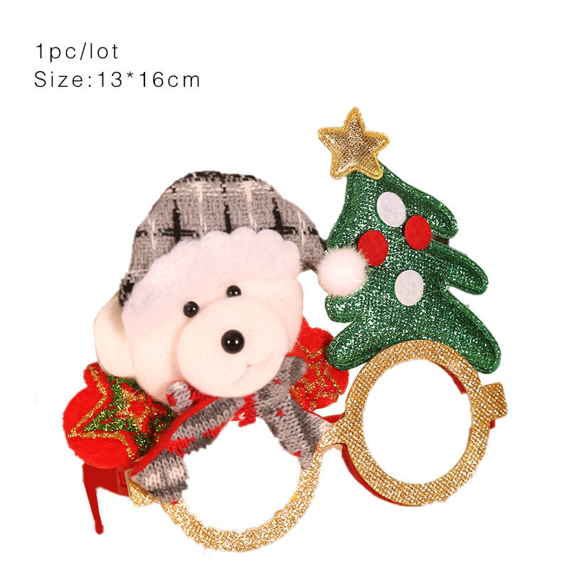 Festive glasses adorned with a plush bear wearing a gray hat and scarf on one side, and a glittering Christmas tree with a star and ornaments on the other. Size: 13x16cm.