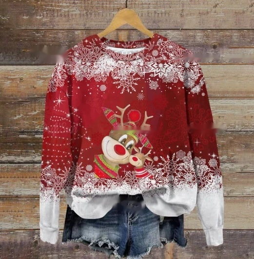 Red Christmas sweater with reindeer and snowflakes, paired with denim shorts, displayed on a wooden hanger against a rustic wooden background.