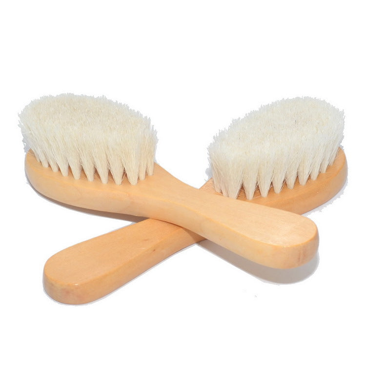 Two wooden brushes with soft white bristles are crossed on a white background. The handles have a smooth finish, and the brushes are arranged in an X shape.