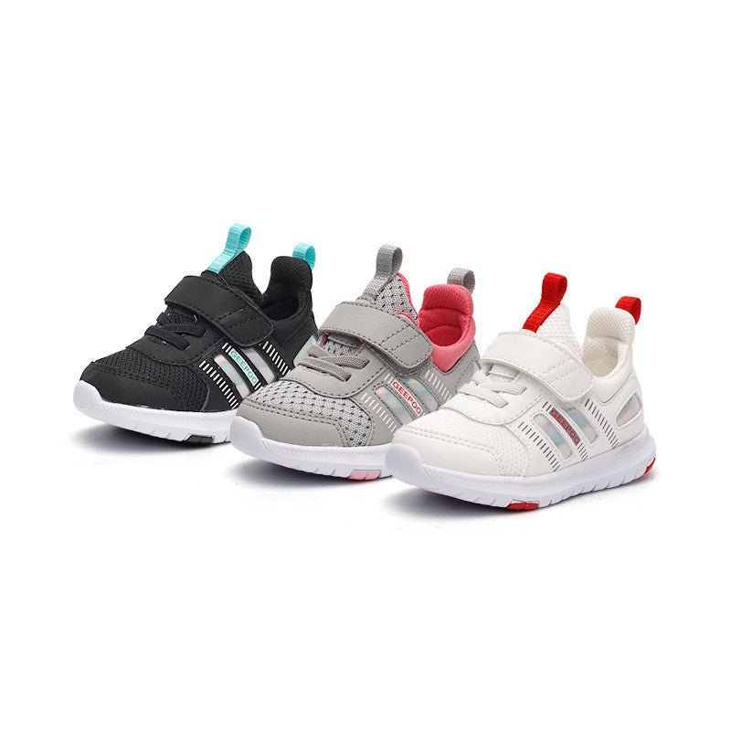 Three pairs of children's sneakers with Velcro straps: black with turquoise accents, gray with pink lining, and white with red details, all with white soles.