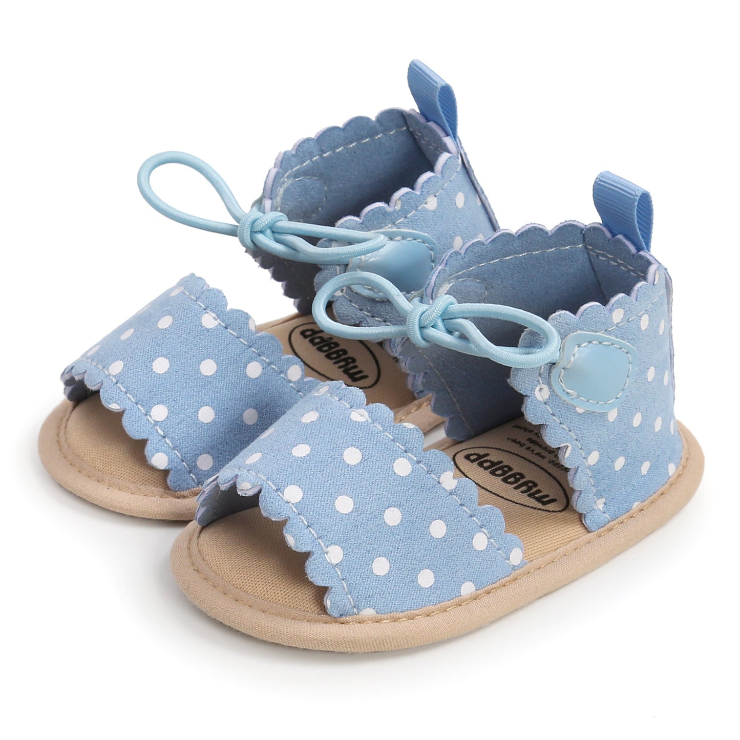 Light blue baby sandals with white polka dots and scalloped edges, featuring a bow detail and soft beige sole, designed for comfort and style.