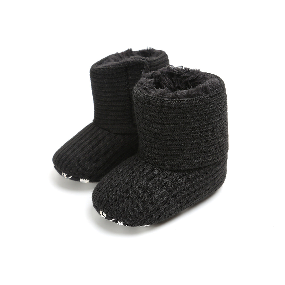 Black ribbed baby booties with soft fuzzy lining and thick cuffs, featuring white accents on the sole. Designed for warmth and comfort, they rest on a plain white background.