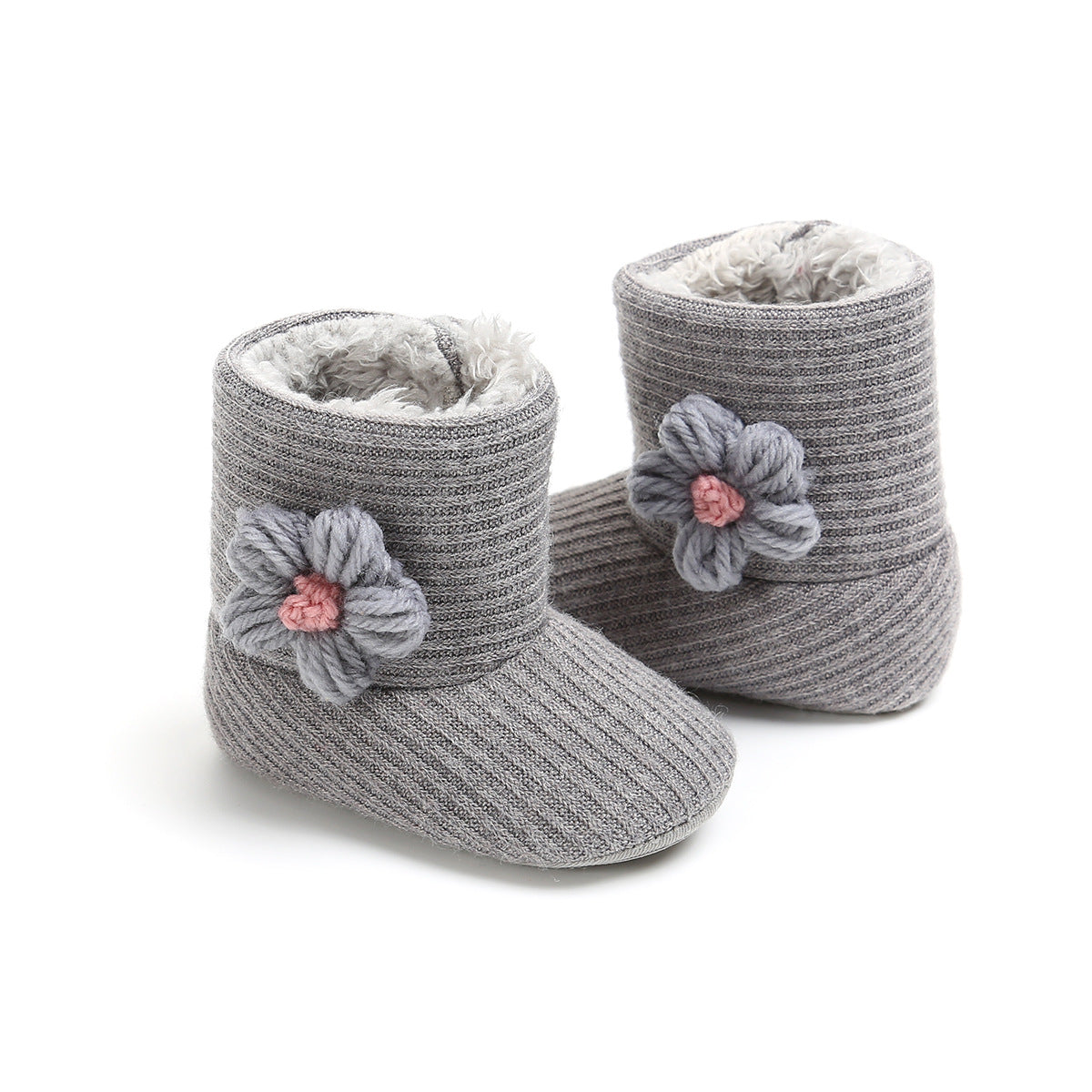 Gray knitted baby booties with a ribbed texture, featuring a soft, fluffy interior and embellished with a large knitted flower decoration on each side.