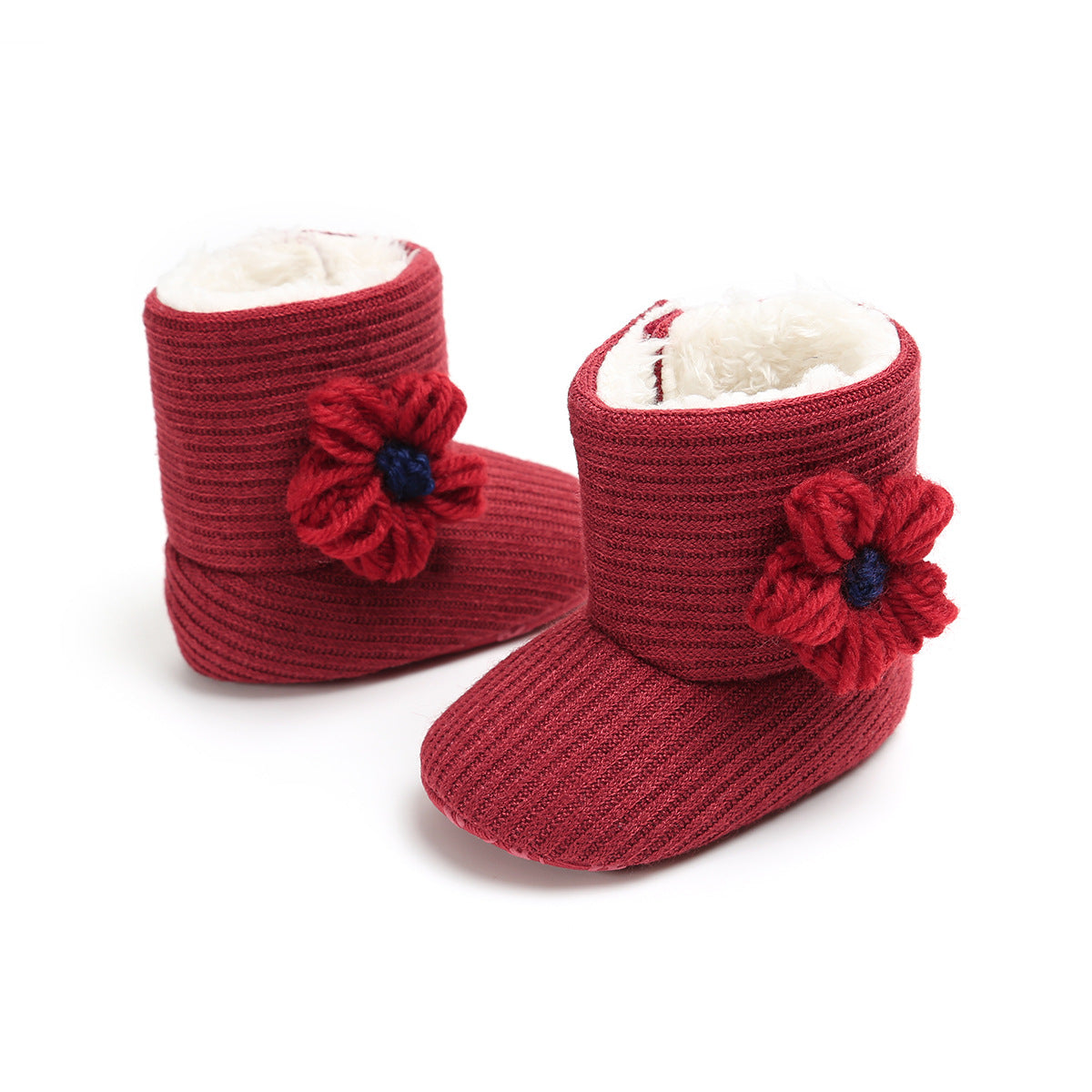 Red knitted baby booties with floral decorations on the side, featuring ribbed texture and a soft white lining inside.
