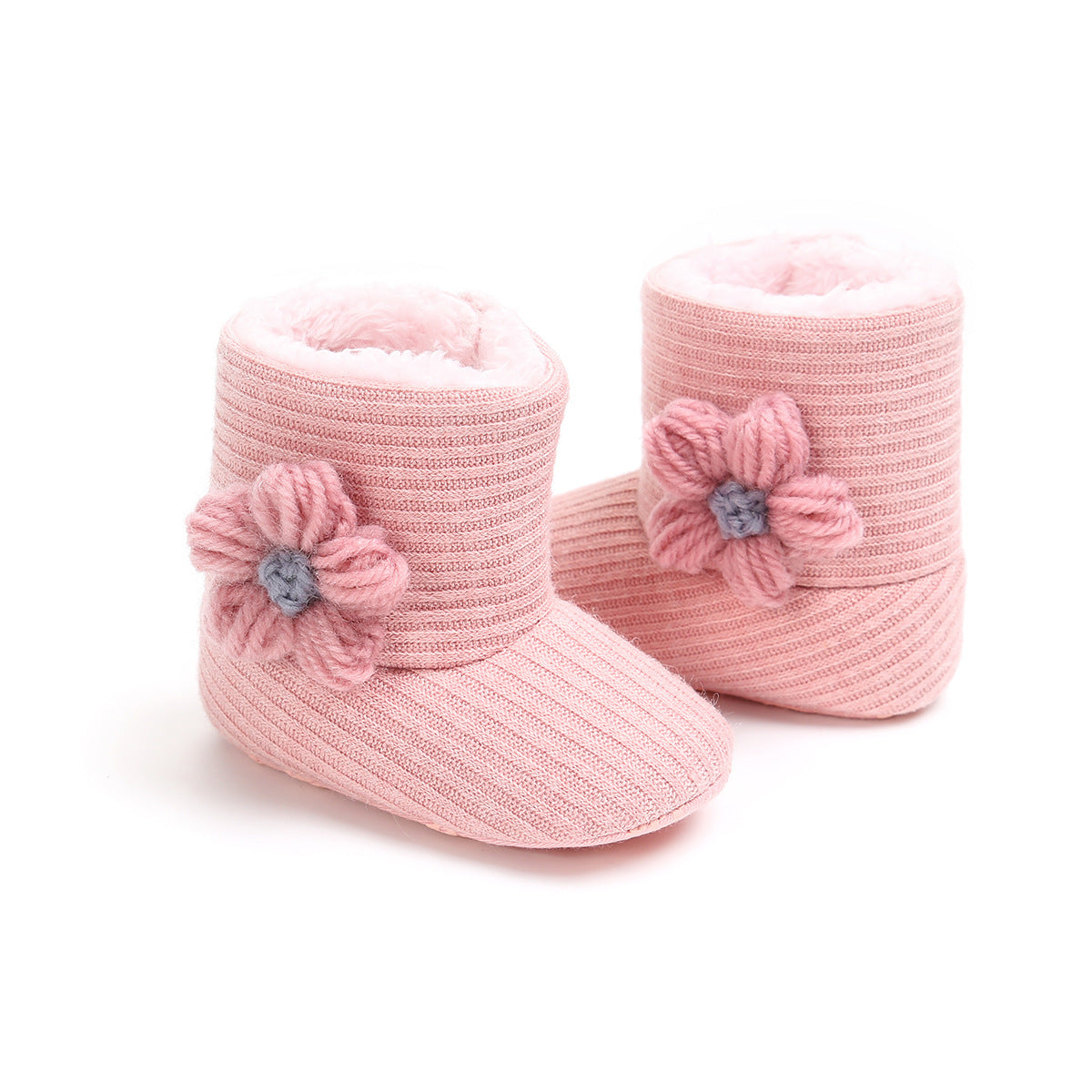 Pink knitted baby booties with soft lining, featuring a ribbed texture and a decorative flower on each side. Perfect for keeping little feet warm and cozy.