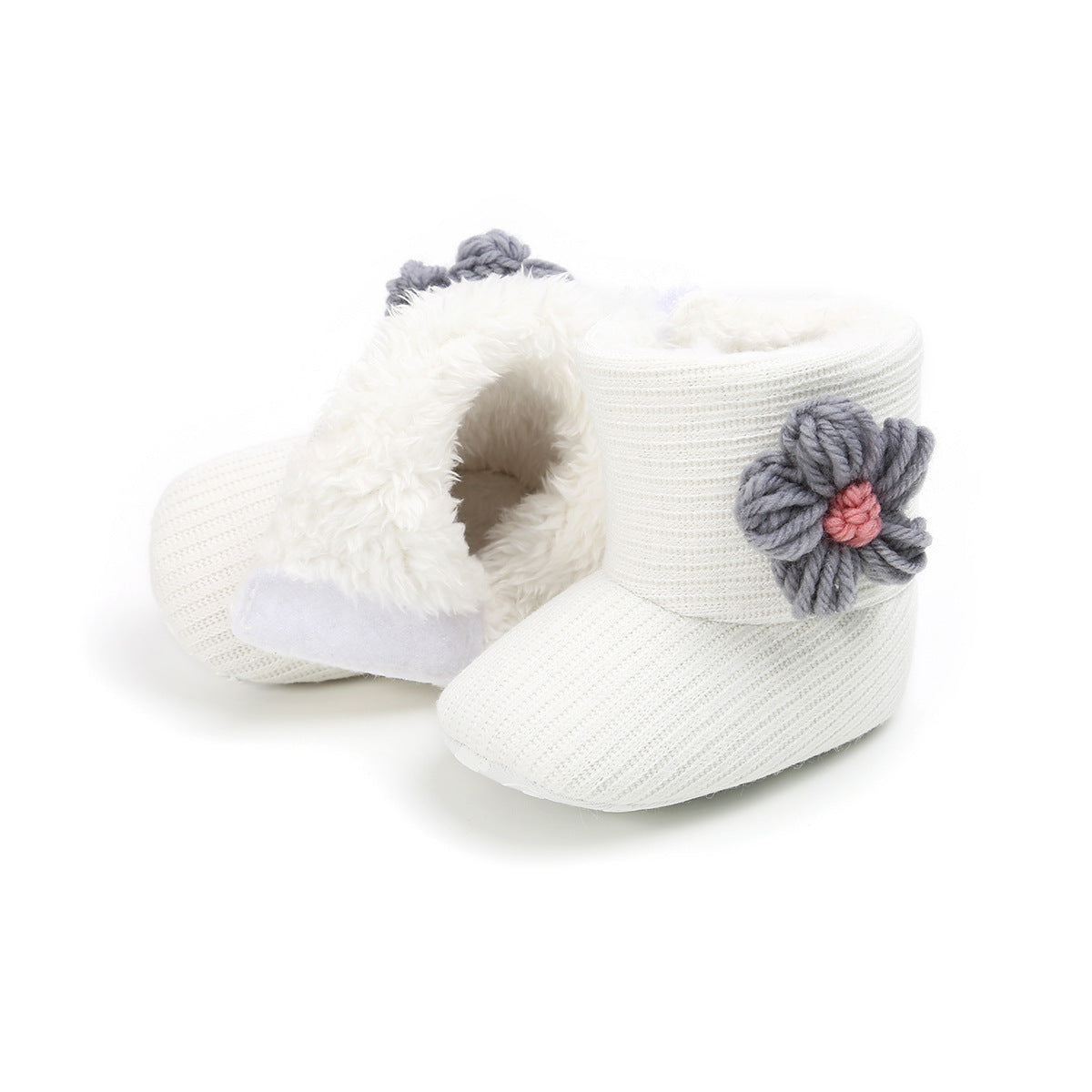 White knitted baby booties with fluffy lining, featuring a gray and pink yarn flower on each side.
