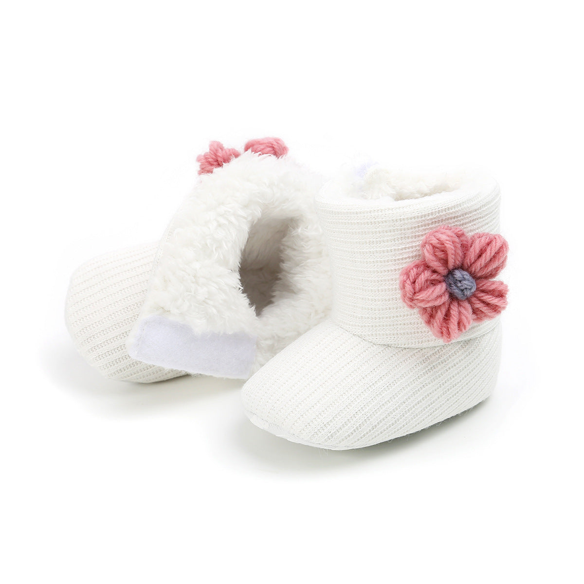 White knitted baby booties with a soft, fluffy lining, adorned with pink crochet flower accents. The booties are cozy and stylish, perfect for keeping a baby's feet warm.