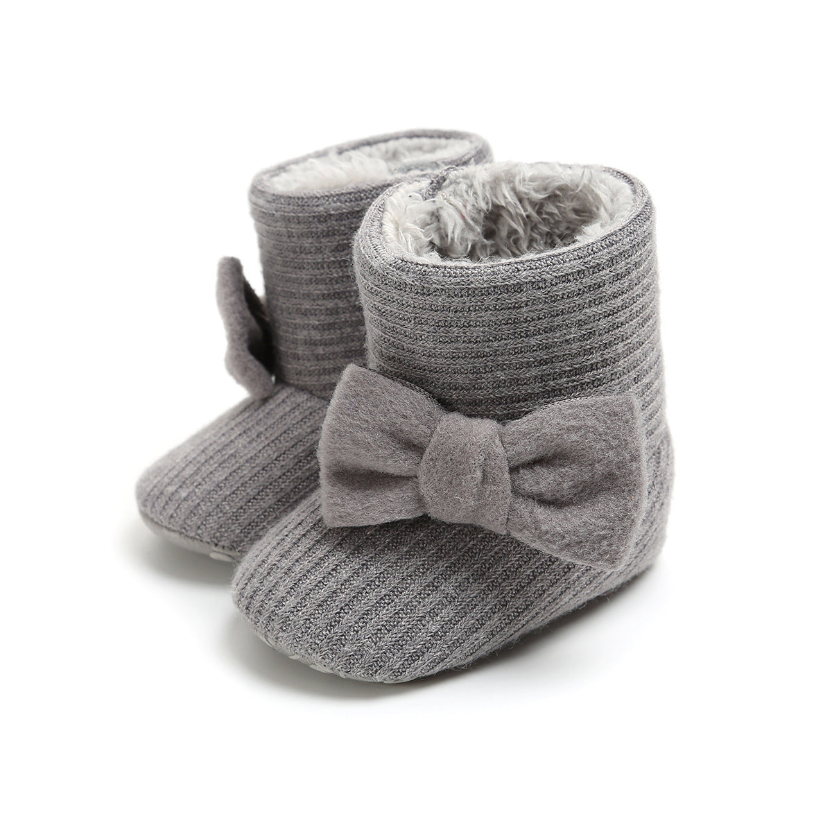 Gray knitted baby booties with a soft, furry interior and large fabric bows on the sides. The booties have a ribbed texture and stand upright on a white background.