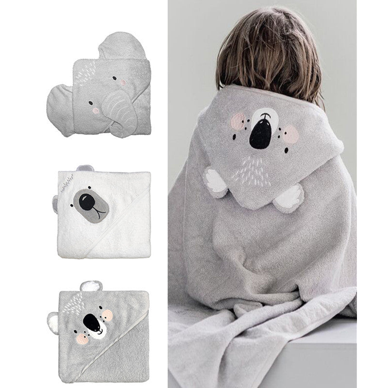 Three hooded towels with animal designs: gray elephant, white bear, gray koala. A child wears the koala towel. Each towel has cute embroidered animal faces on the hoods.