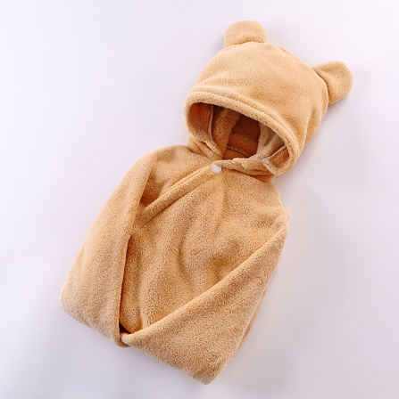 Beige hooded baby romper with bear ears, made of soft, fuzzy fabric. The romper is neatly folded and laid on a white background, emphasizing its cozy texture and cute design.