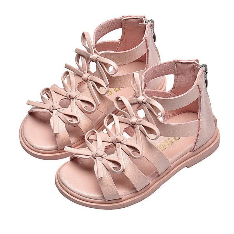 Pink strappy sandals for toddlers with multiple bows on the upper straps and a zipper closure at the back, designed for stylish comfort.