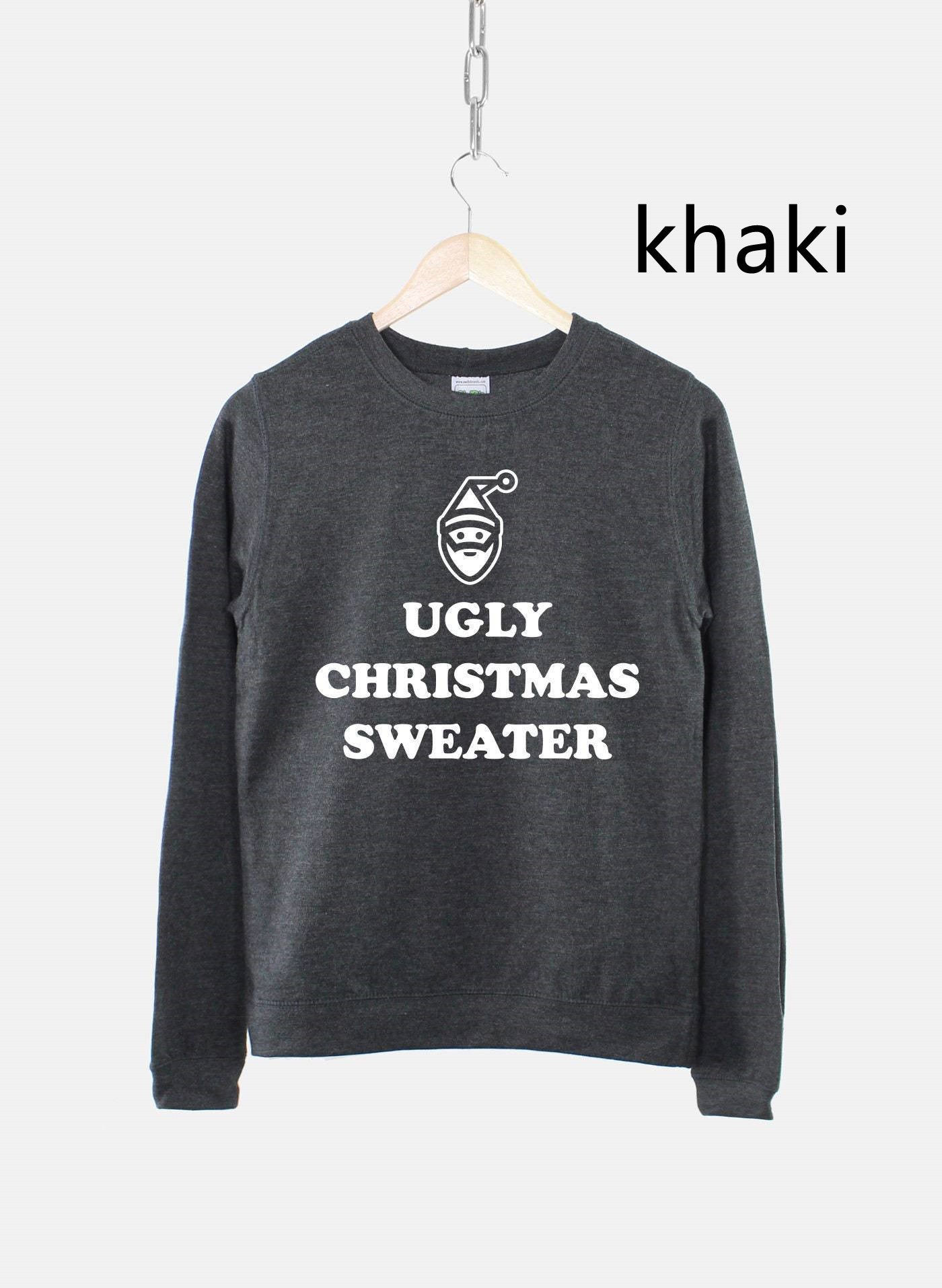 Dark grey sweater on a hanger with the words "Ugly Christmas Sweater" and a small Santa face design printed in white.