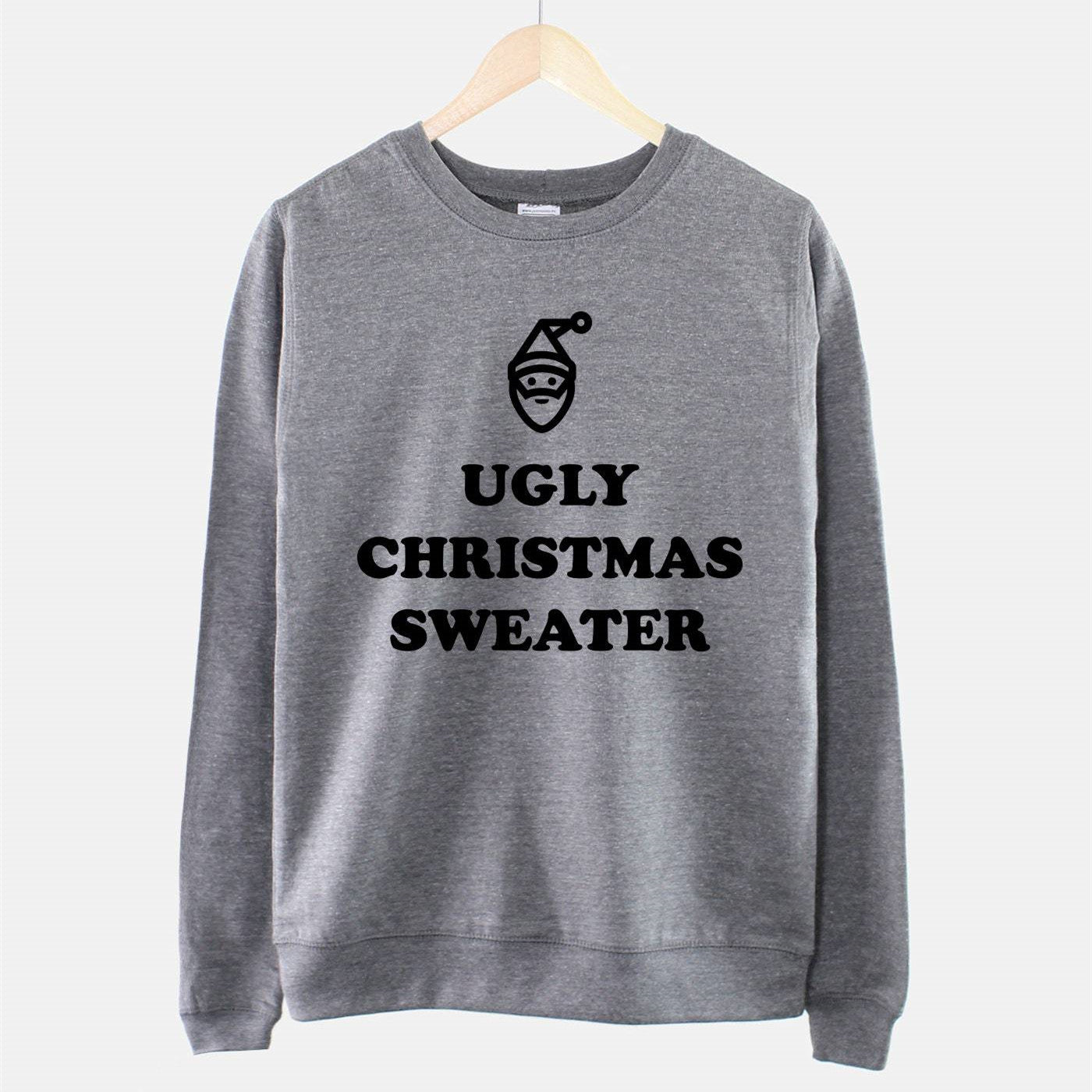Gray sweatshirt on hanger with "Ugly Christmas Sweater" text and a simple Santa face icon.