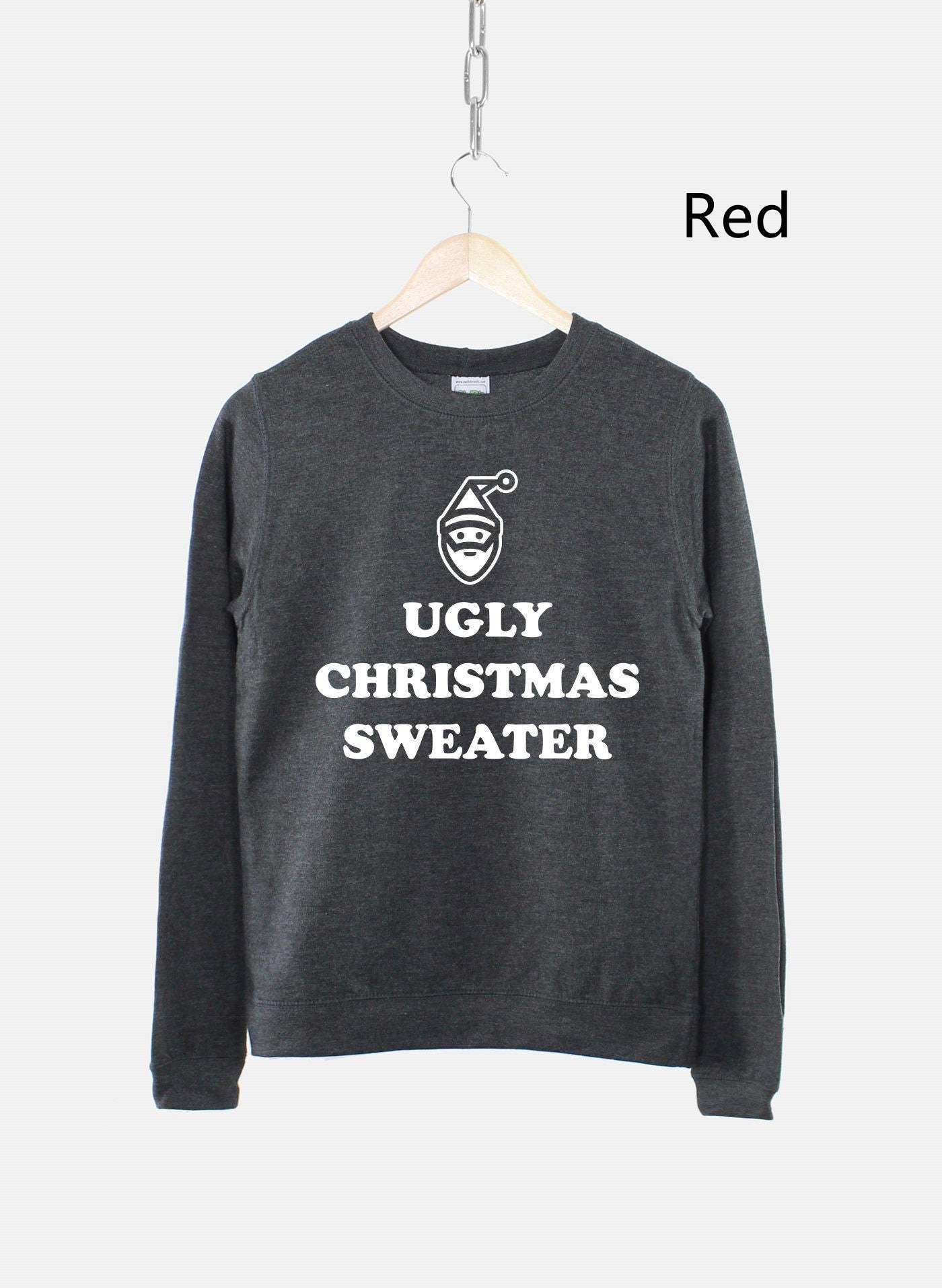 Dark gray sweater on a hanger with "Ugly Christmas Sweater" and a Santa face design in white. Text reading "Red" is beside the sweater on the right.
