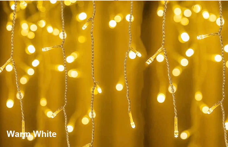 Warm white LED string lights hanging vertically against a soft, out-of-focus background creating a cozy, festive ambiance.