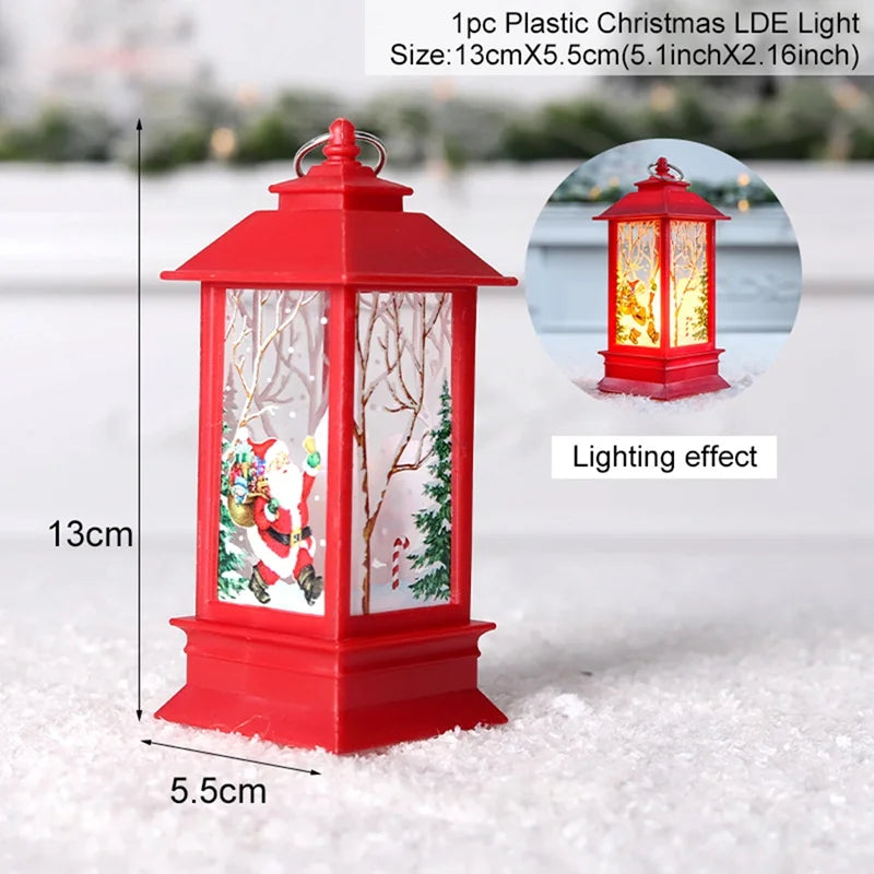 Red plastic Christmas lantern with Santa and tree design, measuring 13cm tall and 5.5cm wide. Includes an inset showing its warm LED lighting effect. Snowy surface background.