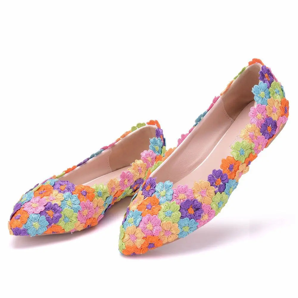 Colorful flats covered in a vibrant floral crochet pattern, featuring pink, blue, yellow, orange, purple, and green flowers with a pointed toe design.