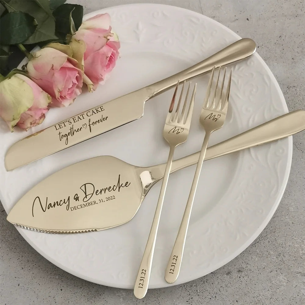 Gold wedding cake server set engraved with couple's names and date, arranged on a white plate with pink roses. Knife reads "Let's eat cake together forever."
