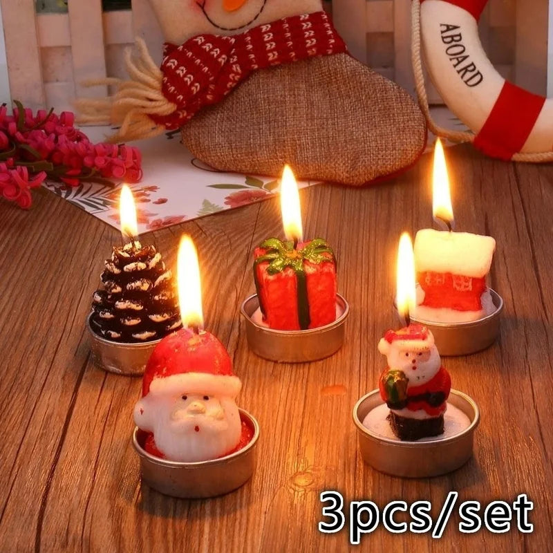 Festive tea light candles shaped like Santa, a gift, pinecone, and house, burning brightly on a wooden surface. Background includes holiday decor and text "3pcs/set."