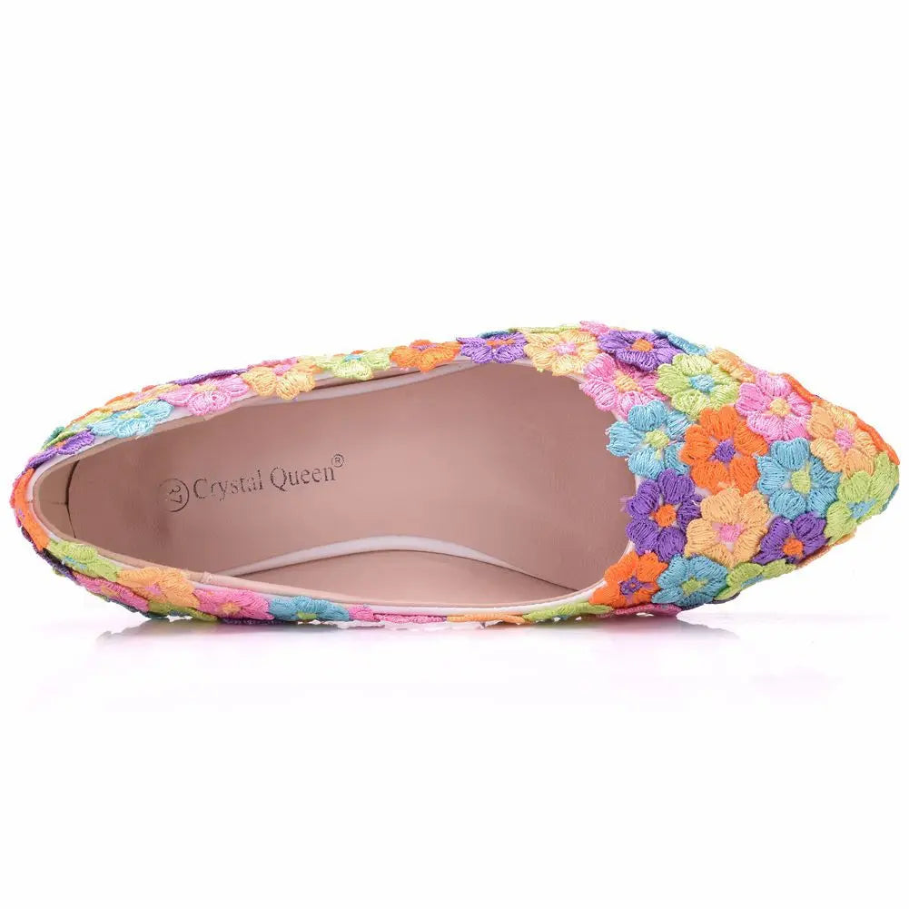 Top view of a colorful women's flat shoe decorated with multicolored floral embroidery in shades of orange, yellow, pink, purple, and blue. The insole bears the label "Crystal Queen."
