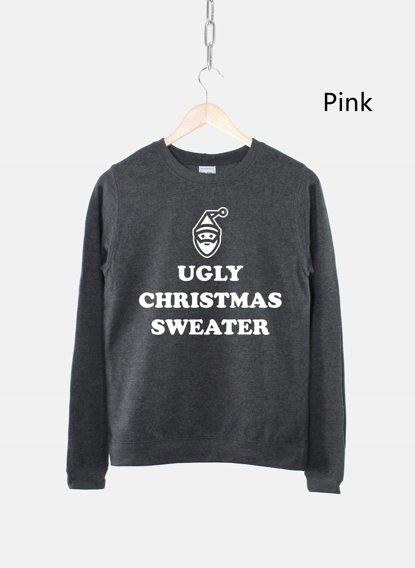 Dark gray sweater with "Ugly Christmas Sweater" text and a stylized Santa face printed in white. Hangs on wooden hanger against a light background.